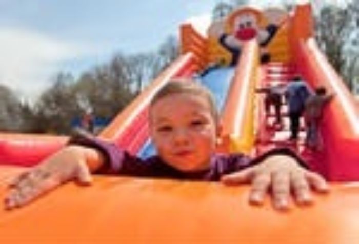 Stock photo smiling little boy playing on inflatable slide looking at camera 95618731