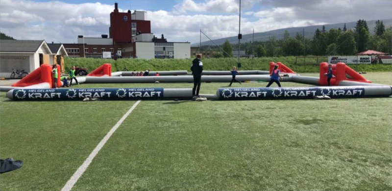 Oppblasbar 3-er fotballbane i bruk med sponsor helgeland kraft reklame banner