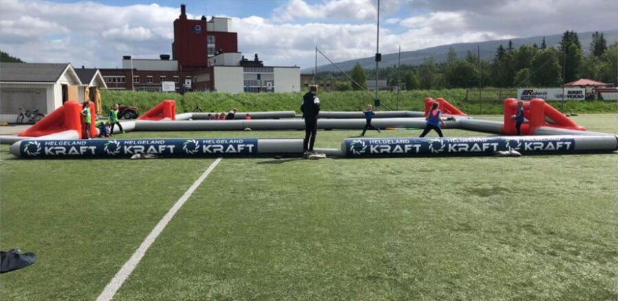 Oppblasbar 3-er fotballbane i bruk med sponsor helgeland kraft reklame banner